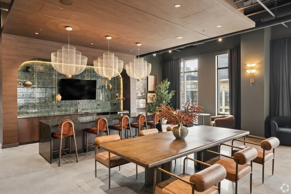 Resident lounge with leather seating, a pool table, bar tables, and a marble-topped bar.