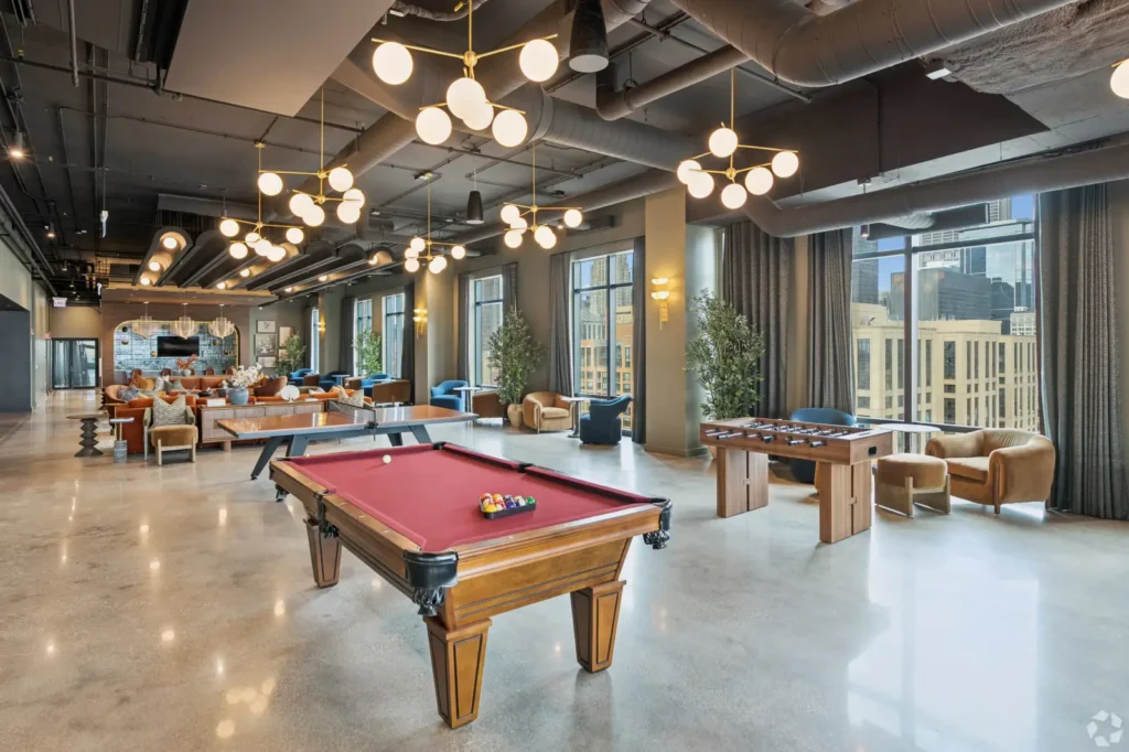 Resident lounge with a pool table, leather seating, bar tables, and Chicago skyline views.