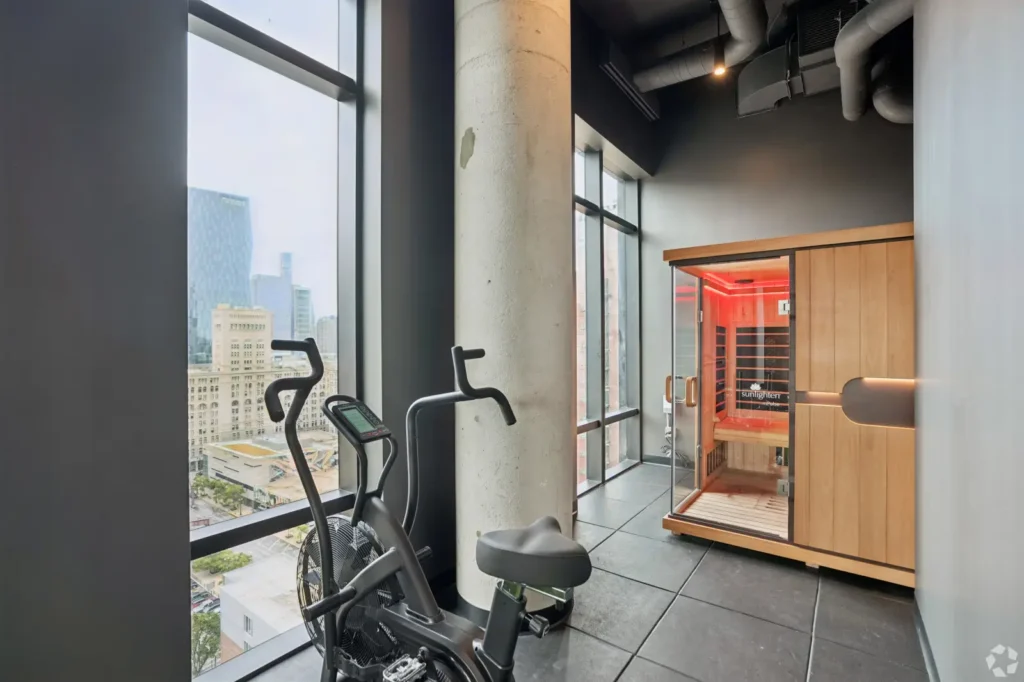 Fitness center with treadmills, elliptical machines, weight equipment, and a view of the pool.